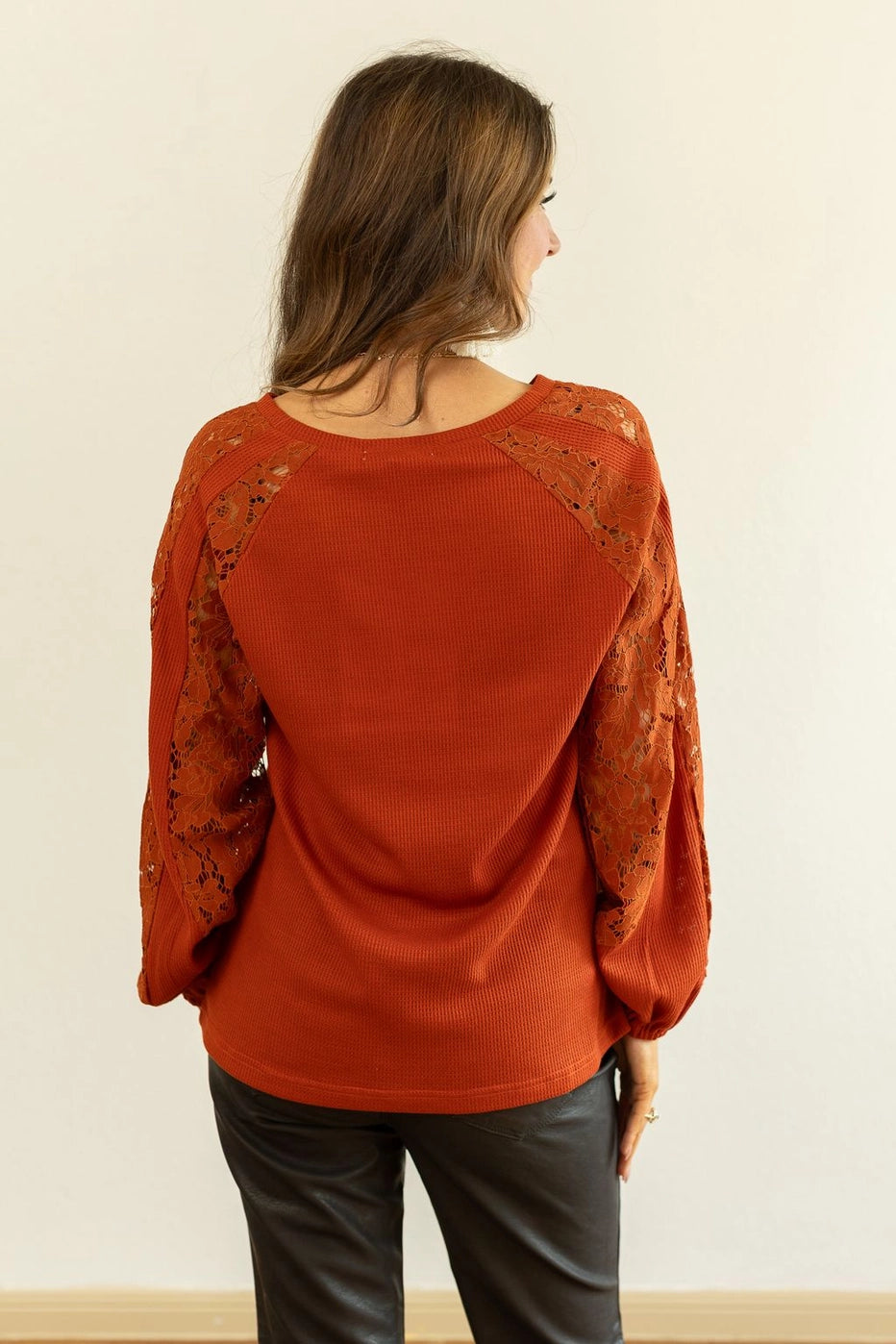 Rust Lace Sleeve V-Neck Top is a perfect balance of casual elegance and comfort. Designed with a relaxed fit and some stretch, this top features a flattering V-neckline and intricate lace inserts on the sleeves.