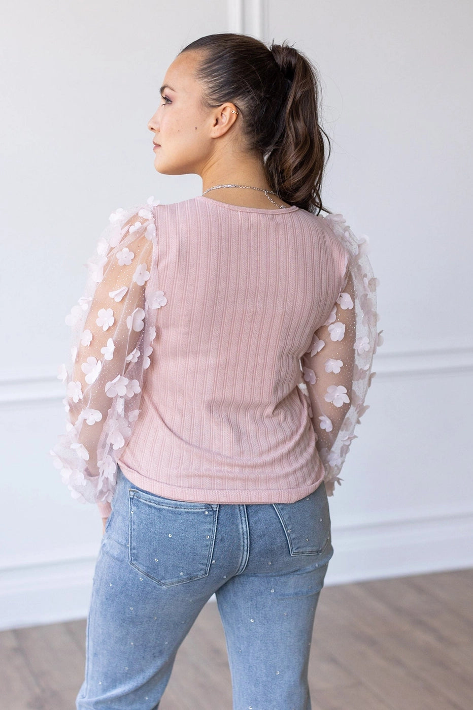 Floral Sleeve Top brings a touch of elegance and charm to your wardrobe. Designed with sheer puff sleeves adorned with 3D floral appliqués and a soft V-neckline.