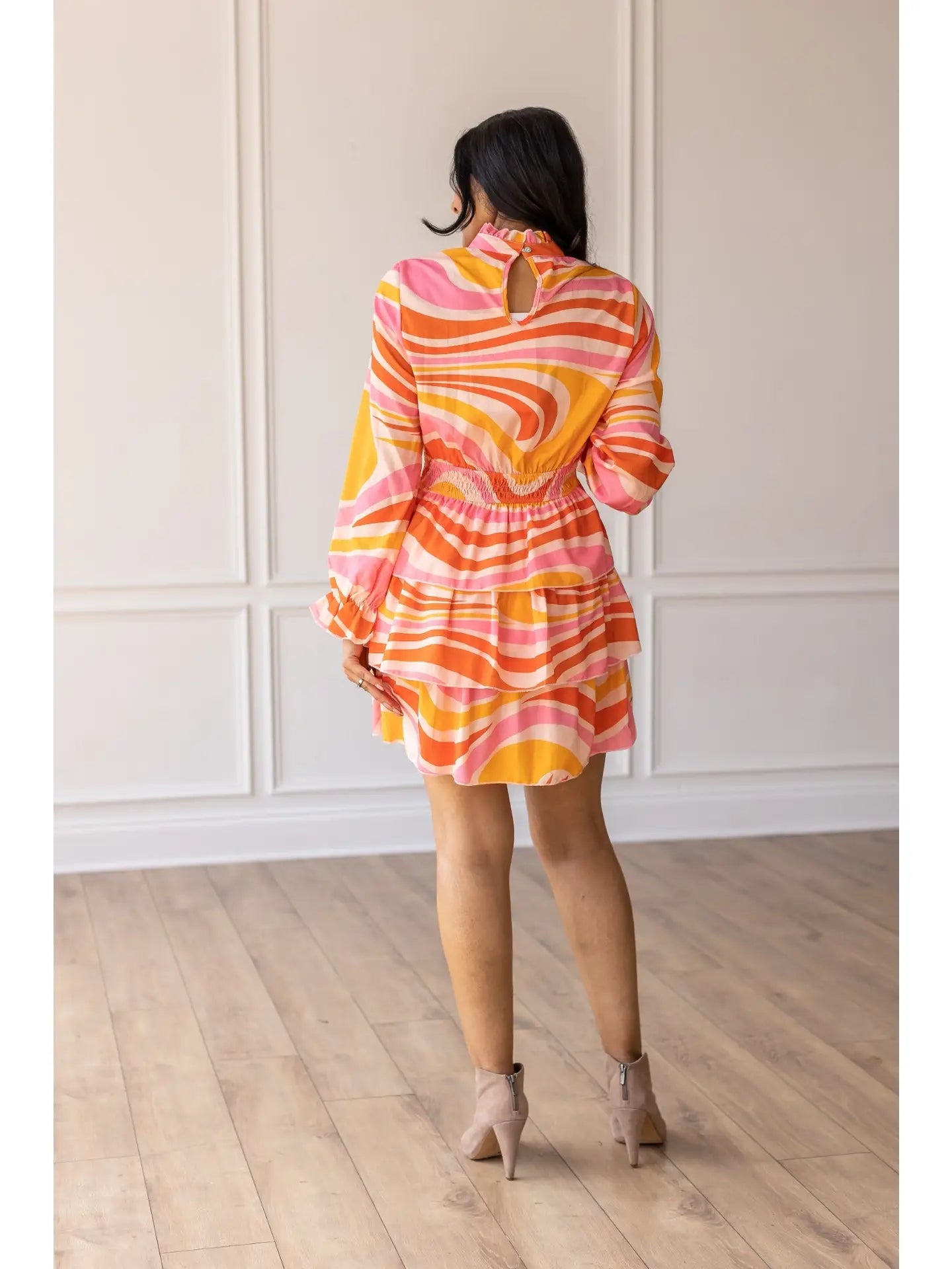 Swirl Print Dress is a vibrant and playful piece perfect for making a statement. Featuring a bold swirl pattern and a flattering smocked waist.