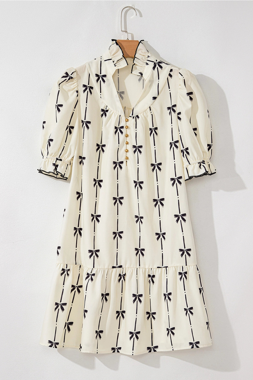 Bow Print Dress. The short puff sleeves and tiered hem create a flattering silhouette, while the high neckline with a button-front detail.