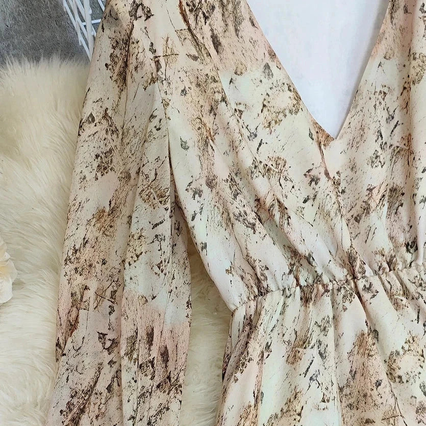 Cream Floral Ruffle Maxi Dress is a dreamy and romantic piece that exudes effortless elegance. Featuring a deep V-neckline and long, sheer sleeves.