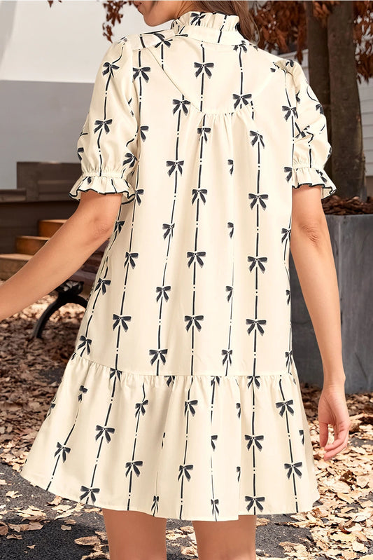 Bow Print Dress. The short puff sleeves and tiered hem create a flattering silhouette, while the high neckline with a button-front detail.