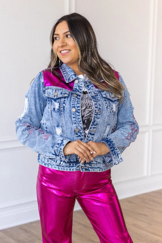 Denim Jacket is a striking blend of classic denim and glamorous details. Featuring a fitted silhouette, distressed touches, vibrant satin panels, and jeweled accents.