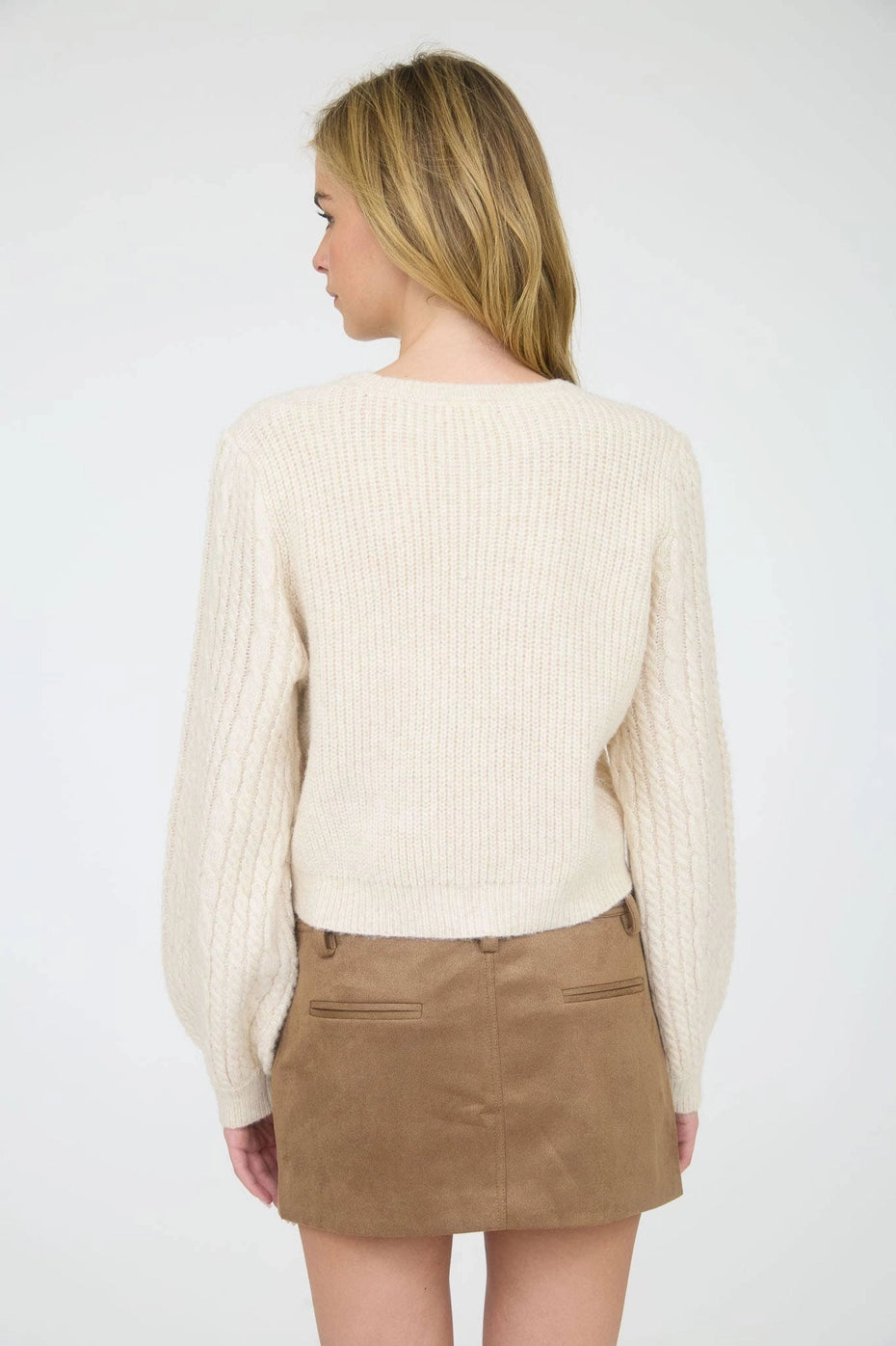 Cream Velvet Bow Cable Knit Sweater is a cozy and stylish addition to your wardrobe. Featuring a classic cable knit pattern and a round crew neckline.