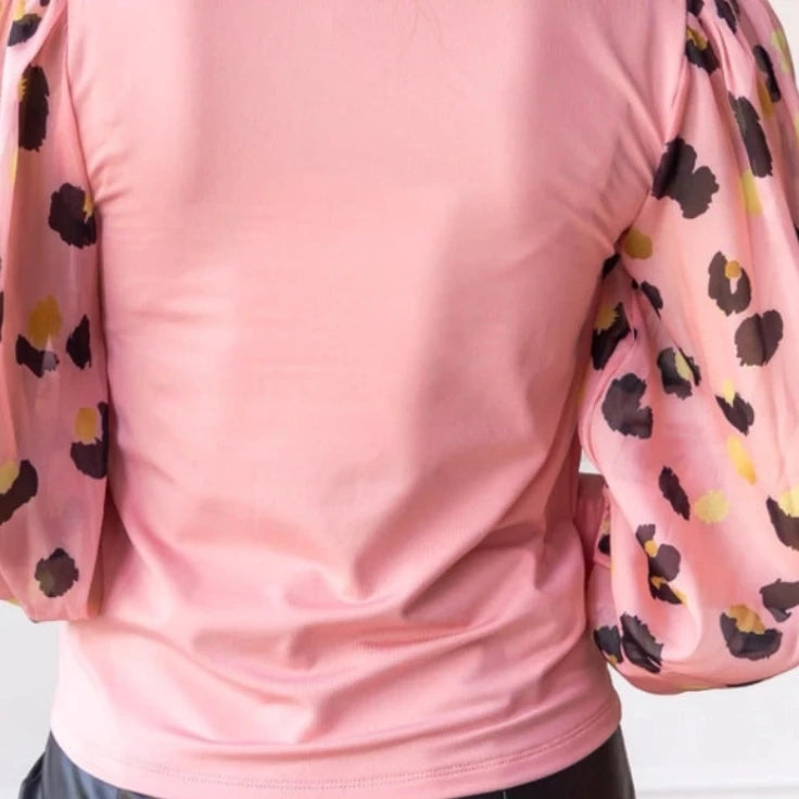 Pink Leopard Sleeve Top is a stylish blend of simplicity and boldness. Featuring sheer leopard-print puff sleeves and a sleek solid bodice.