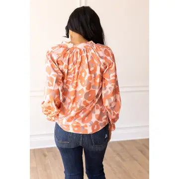Coral Leopard Blouse. Featuring a relaxed fit, bold coral leopard print, and charming ruffle details on the cuffs.