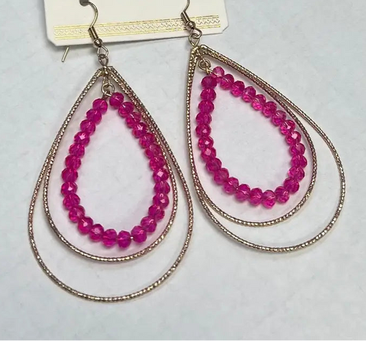 Teardrop-shaped pink beaded earrings on a white card.