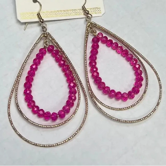 Teardrop-shaped pink beaded earrings on a white card.