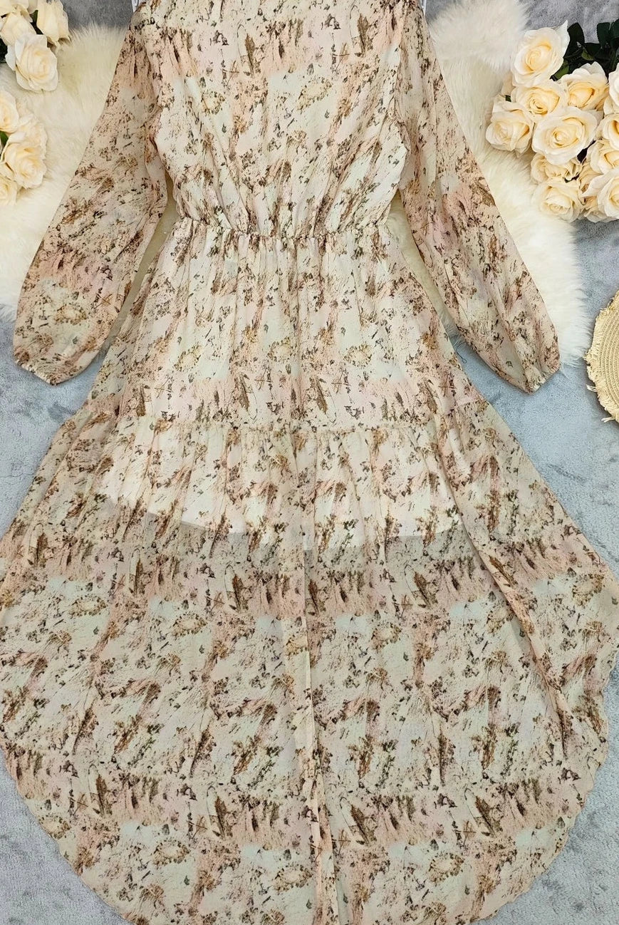 Cream Floral Ruffle Maxi Dress is a dreamy and romantic piece that exudes effortless elegance. Featuring a deep V-neckline and long, sheer sleeves.