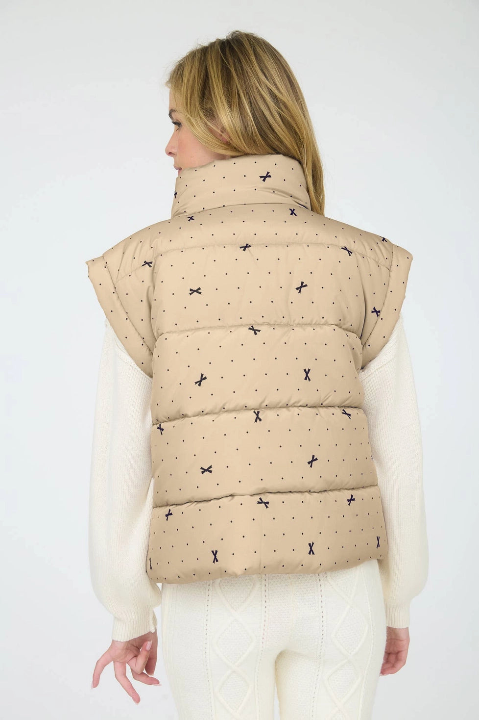 Light Khaki Polka Dot Bow Puffer Vest is a stylish and functional layering piece perfect for cooler weather.