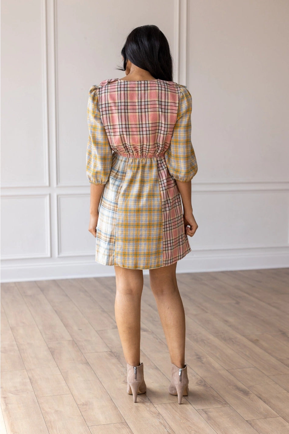 Plaid Ruffle Wrap Dress. Featuring a mix of soft plaid patterns, a flattering wrap design, and ruffled details along the neckline and hem.
