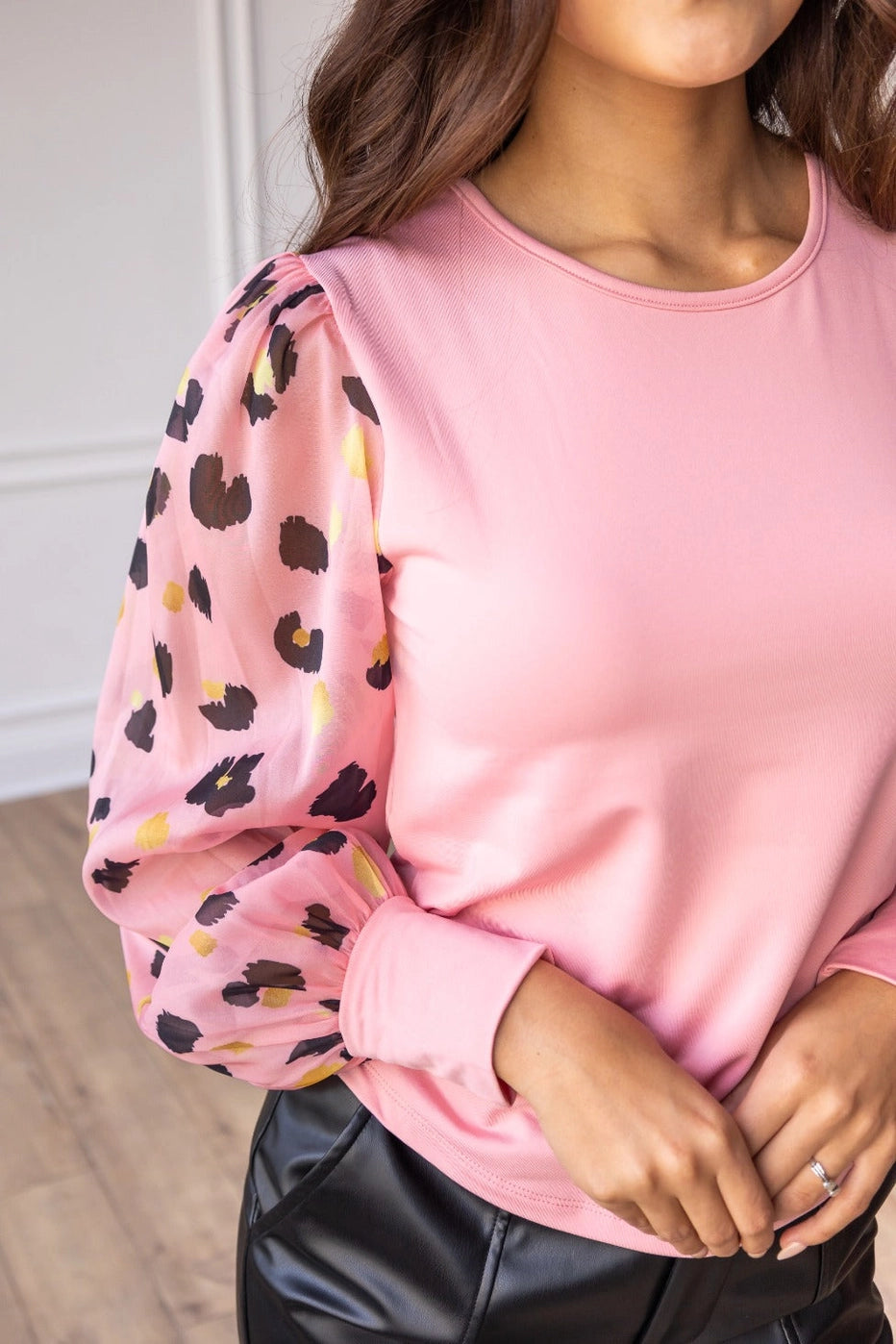 Pink Leopard Sleeve Top is a stylish blend of simplicity and boldness. Featuring sheer leopard-print puff sleeves and a sleek solid bodice.