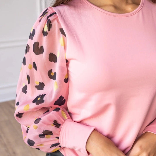 Pink Leopard Sleeve Top is a stylish blend of simplicity and boldness. Featuring sheer leopard-print puff sleeves and a sleek solid bodice.