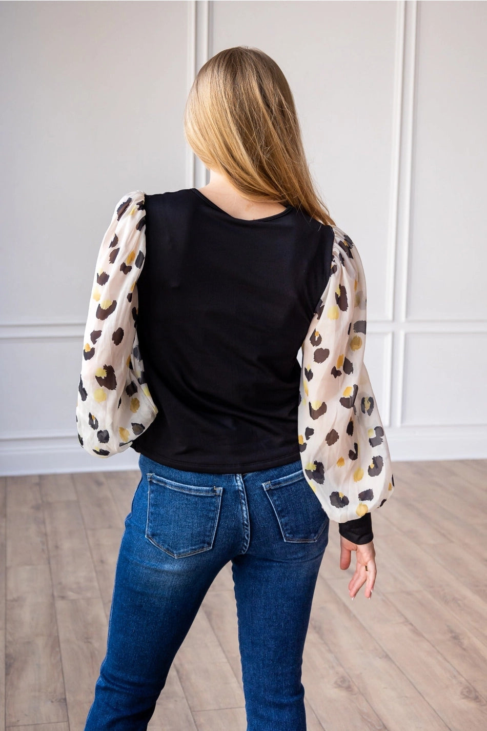 Leopard Sleeve Top is a stylish blend of simplicity and boldness. Featuring sheer leopard-print puff sleeves and a sleek solid bodice.