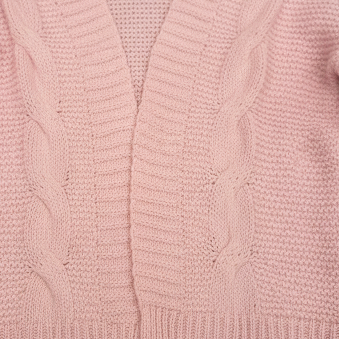 Close-up of a pink cable knit sweater