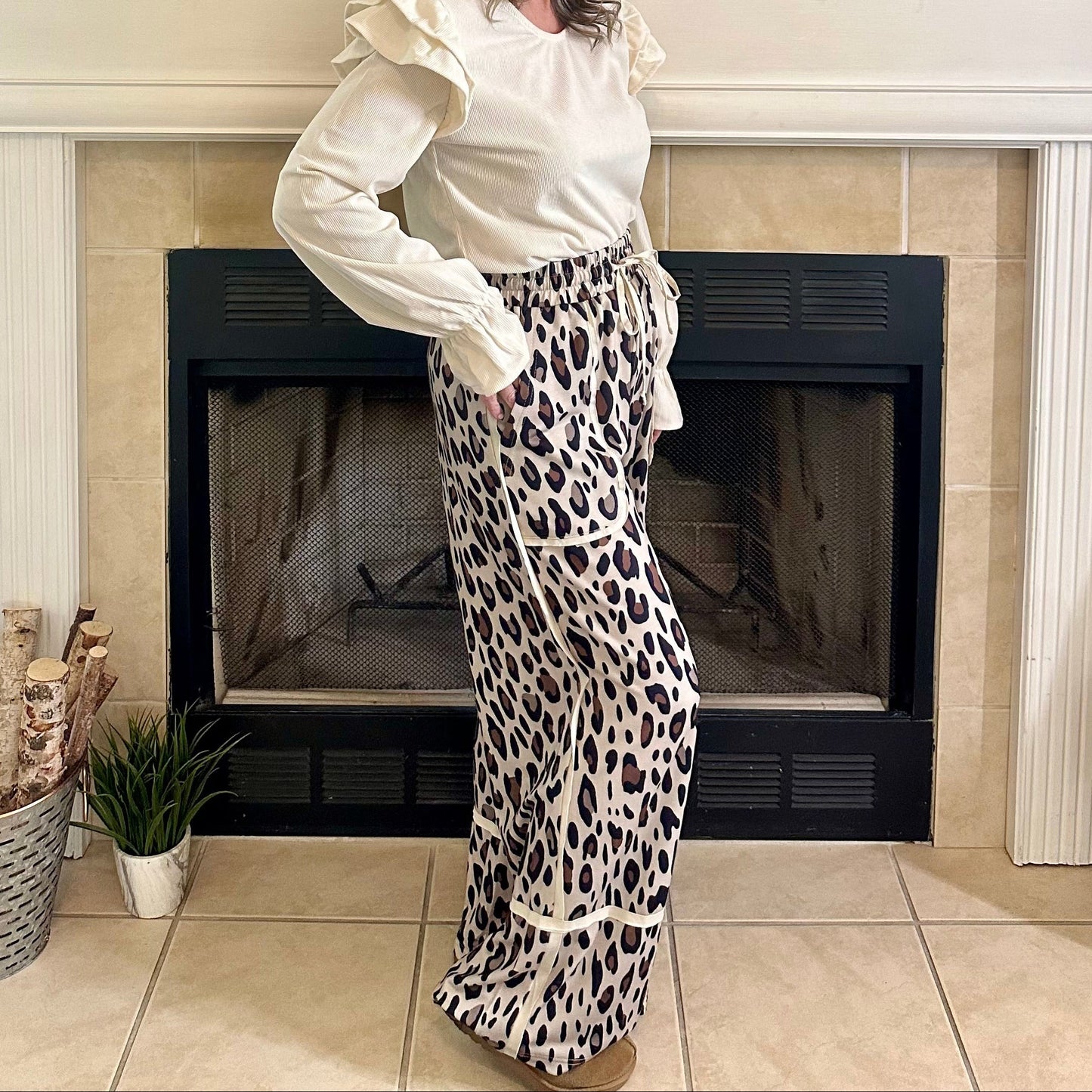 Woman standing in a living room with a decorated fireplace
