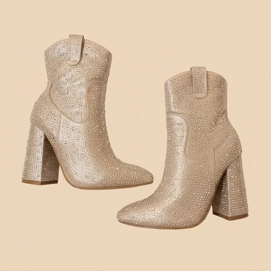 Pair of glittery beige ankle boots on a beige background