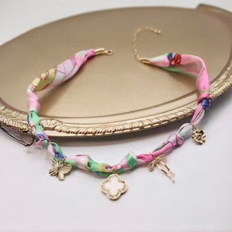 Colorful braided bracelet with charms on a decorative plate
