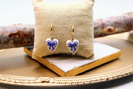 Heart-shaped earrings with blue and white designs.