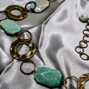 Belt set with turquoise stones and gold chains on a satin surface