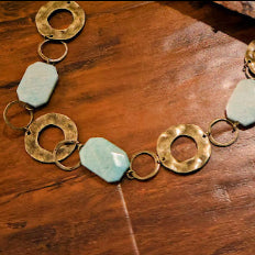 An Accent Belt. This distinctive 46-inch belt features a harmonious blend of textured metal chains and natural stones.