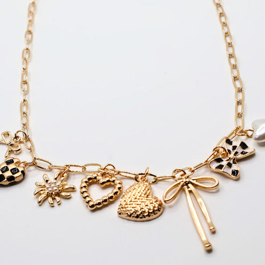 Charm Cascade Necklace Featuring a gold-tone chain adorned with charming pendants, including textured hearts, a delicate bow, a luminous pearl, and checkered-inspired accents.
