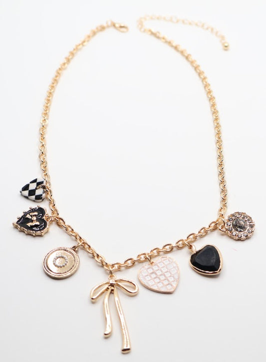 Charm Necklace is a whimsical and eye-catching accessory, perfect for adding character to any outfit. This necklace features a series of unique charms, including hearts, a bow, a sparkling gem, and intricate patterns, all beautifully arranged on a gold-tone chain.