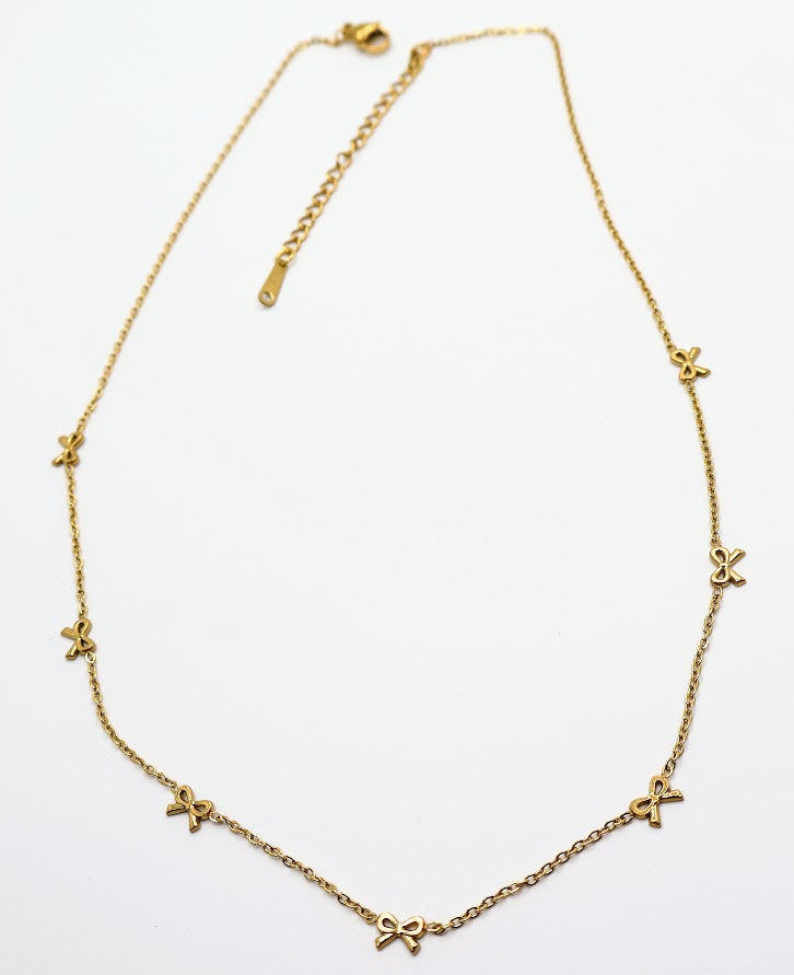 Gold Bow Charm Necklace is a delicate and timeless accessory that exudes elegance and charm. Featuring three dainty bow-shaped accents.