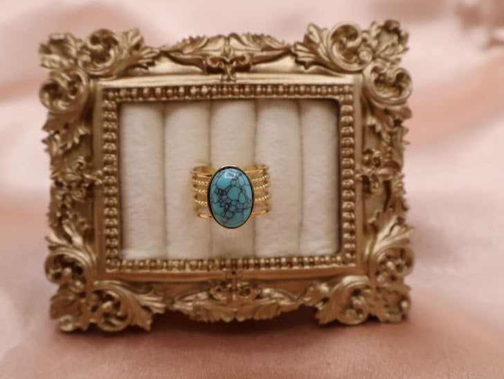 Ring embodies the essence of natural beauty and bohemian elegance. Featuring an oval turquoise stone with captivating veining, set on a layered gold-tone band.