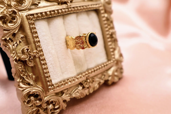 Ring is a bold yet elegant statement piece, designed for those who embrace their unique style. Featuring a striking oval black stone framed by textured gold-tone detailing.