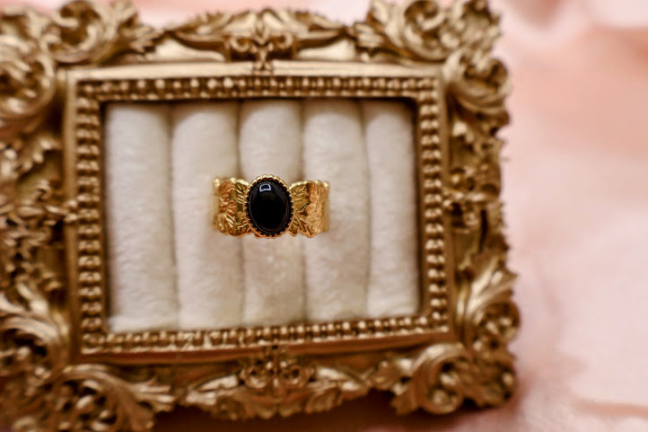 Ring is a bold yet elegant statement piece, designed for those who embrace their unique style. Featuring a striking oval black stone framed by textured gold-tone detailing.