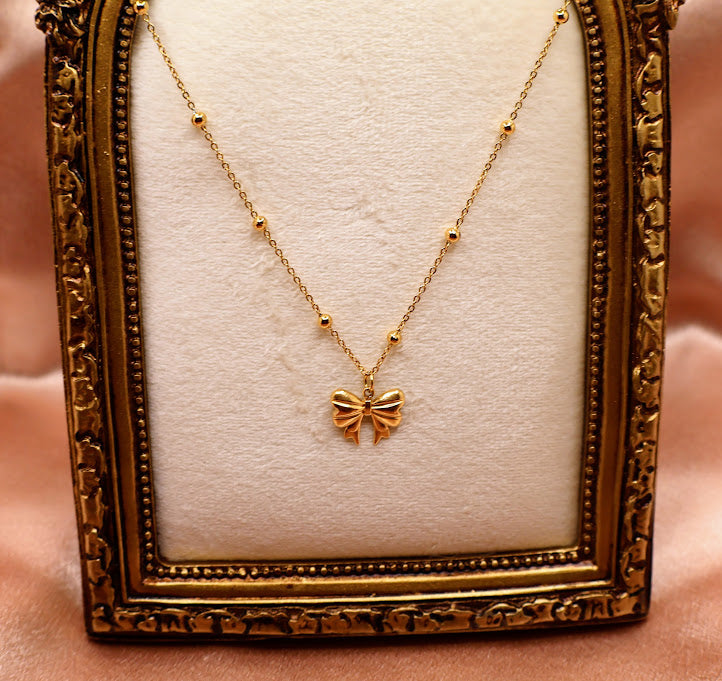 Bow Charm Necklace on dainty gold chain with smal gold beads.