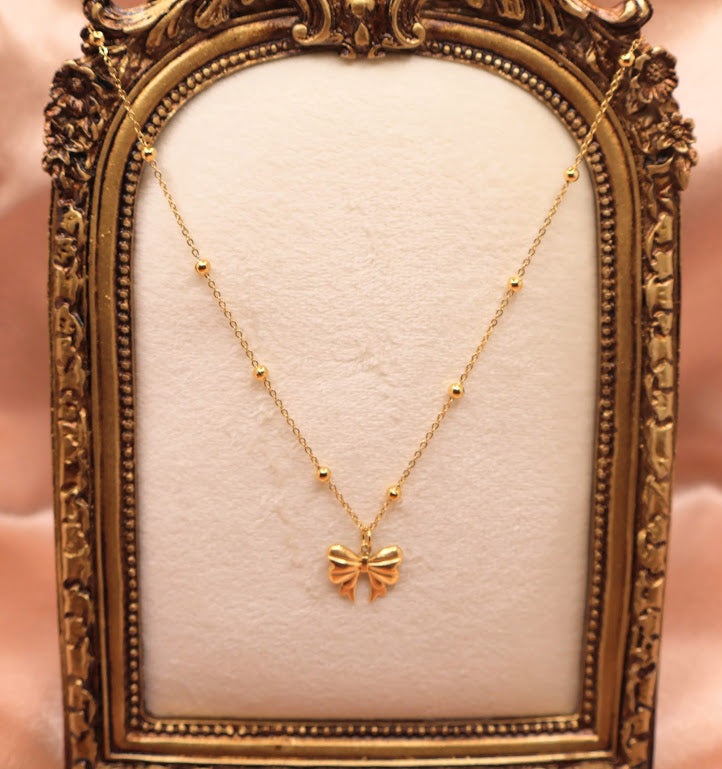 Bow Charm Necklace on dainty gold chain with smal gold beads.