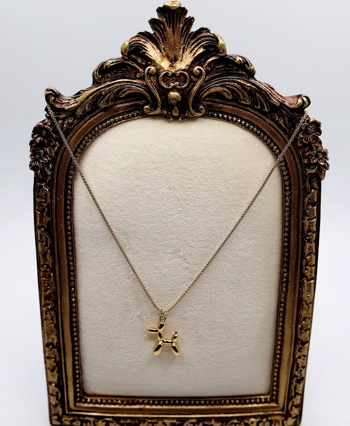 Balloon Dog Charm Necklace is a playful and quirky accessory designed to bring a smile to your face. Featuring a dainty gold-tone balloon animal pendant, this necklace is as fun as it is charming.