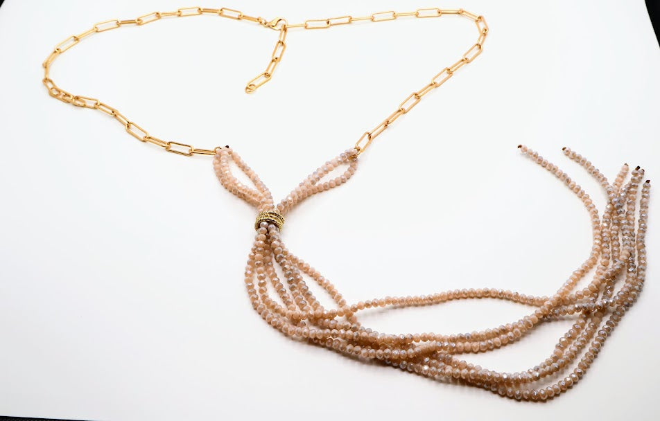 Necklace with multiple strands features a combination of soft blush beads elegantly cascading from a delicate gold chain. The unique Y-shaped design.