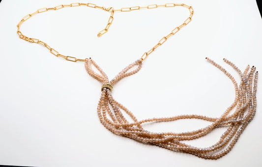 Necklace with multiple strands features a combination of soft blush beads elegantly cascading from a delicate gold chain. The unique Y-shaped design.