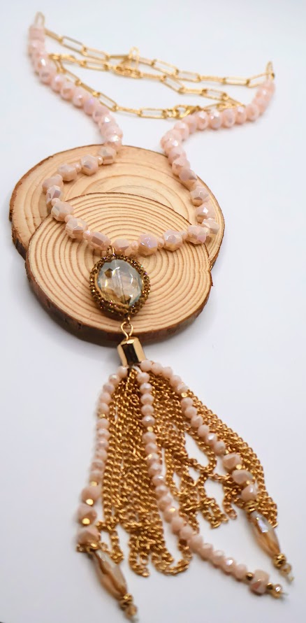 Necklace with blush and gold beads, a luminous gold chain, and an elegant tassel accent.