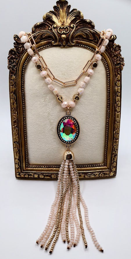 This piece features a stunning iridescent pendant, surrounded by a delicate mix of soft pastel beads and shimmering gold accents.