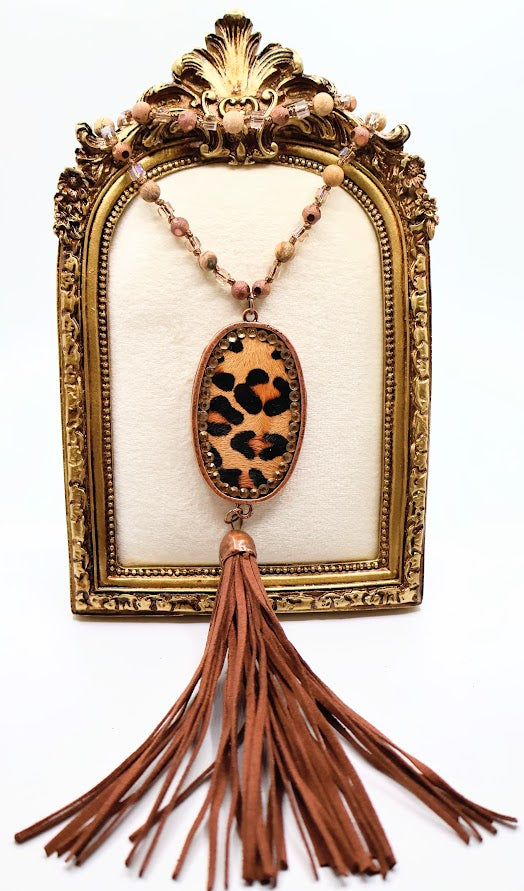 Leopard Tassel Necklace. Highlighting a bold leopard-print pendant, shimmering beaded chain, and a soft suede tassel.