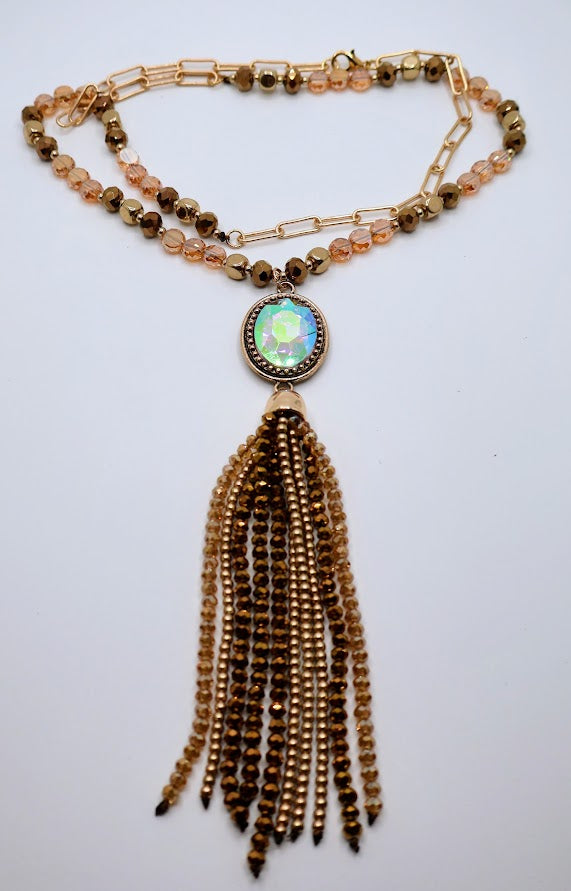 A necklace adorned with colorful details, beautifully framed by a mix of shimmering beads and a playful gold tassel.