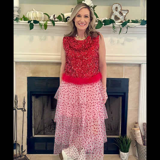 Sequin Feather Crop Top is a bold and glamorous statement piece. Featuring shimmering red sequins and a playful feathered hem.