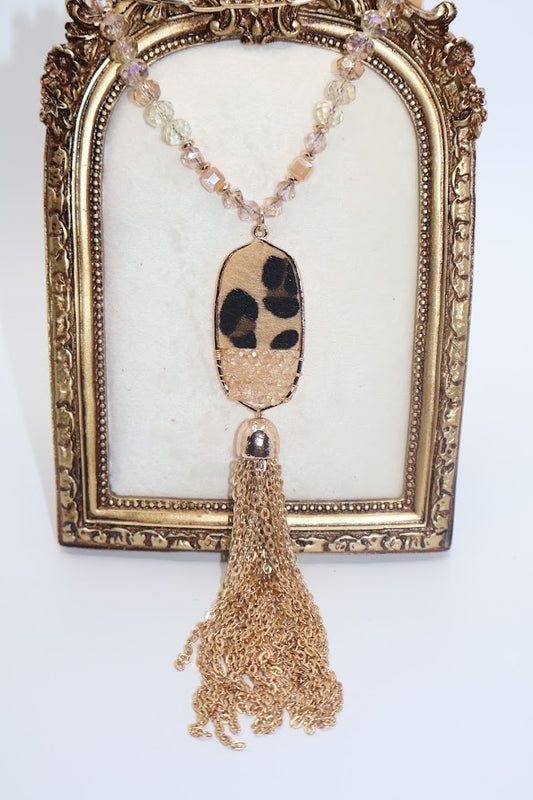 Gold Necklace  features a stunning leopard print pendant adorned with sparkling rhinestones, suspended from a delicate chain of shimmering gold and crystal beads.
