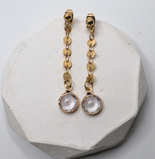 Gold earrings featuring dainty gold chains and sparkling crystal accents.