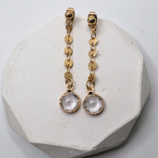Gold earrings featuring dainty gold chains and sparkling crystal accents.