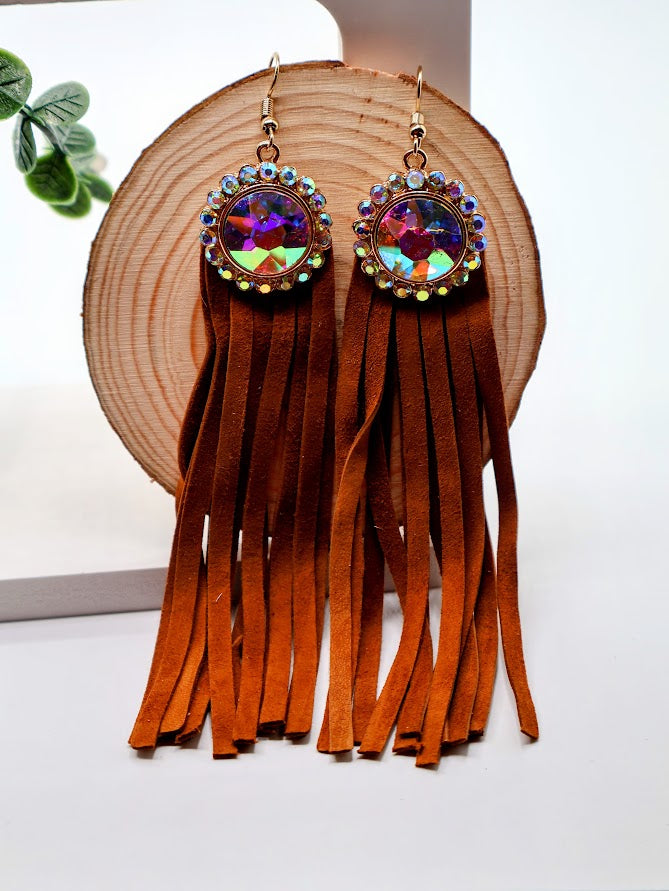 Fringe earrings with colorful gemstones on a wooden stand.