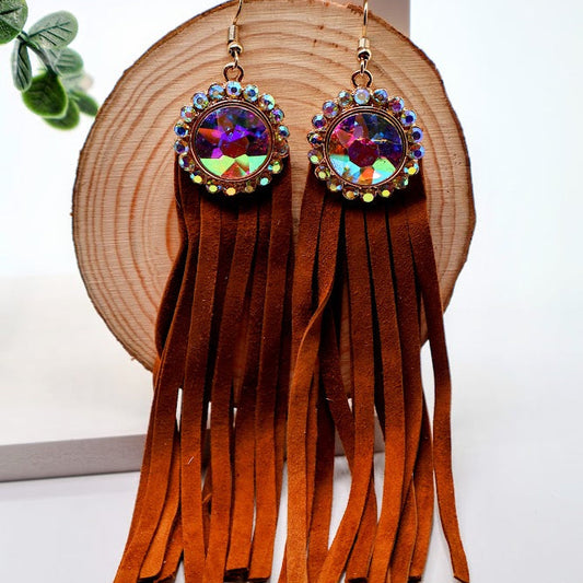 Fringe earrings with colorful gemstones on a wooden stand.