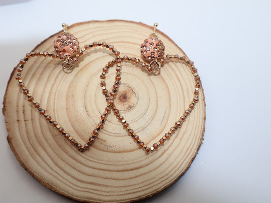 Rosé Glow Heart Earrings. These feminine treasures feature a delicately beaded heart-shaped design in soft rose-gold tones, topped with a sparkling crystal accent for extra charm.