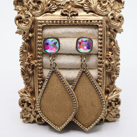 Pair of earrings with colorful gemstones and brown teardrop shapes on a decorative gold stand.