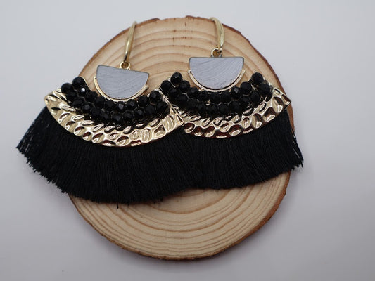 Fan-shaped earrings feature silky black fringe, gold accents, and a sleek geometric design.