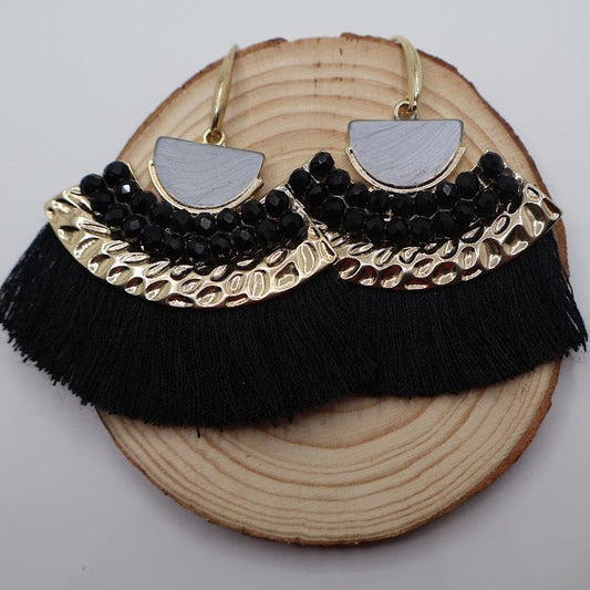 Fan-shaped earrings feature silky black fringe, gold accents, and a sleek geometric design.
